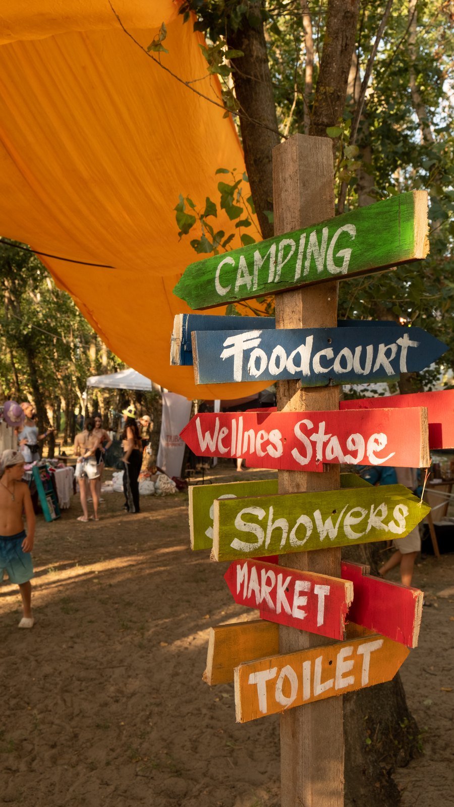 Hand-painted signposts to camping, foodcourt, wellness stage and showers